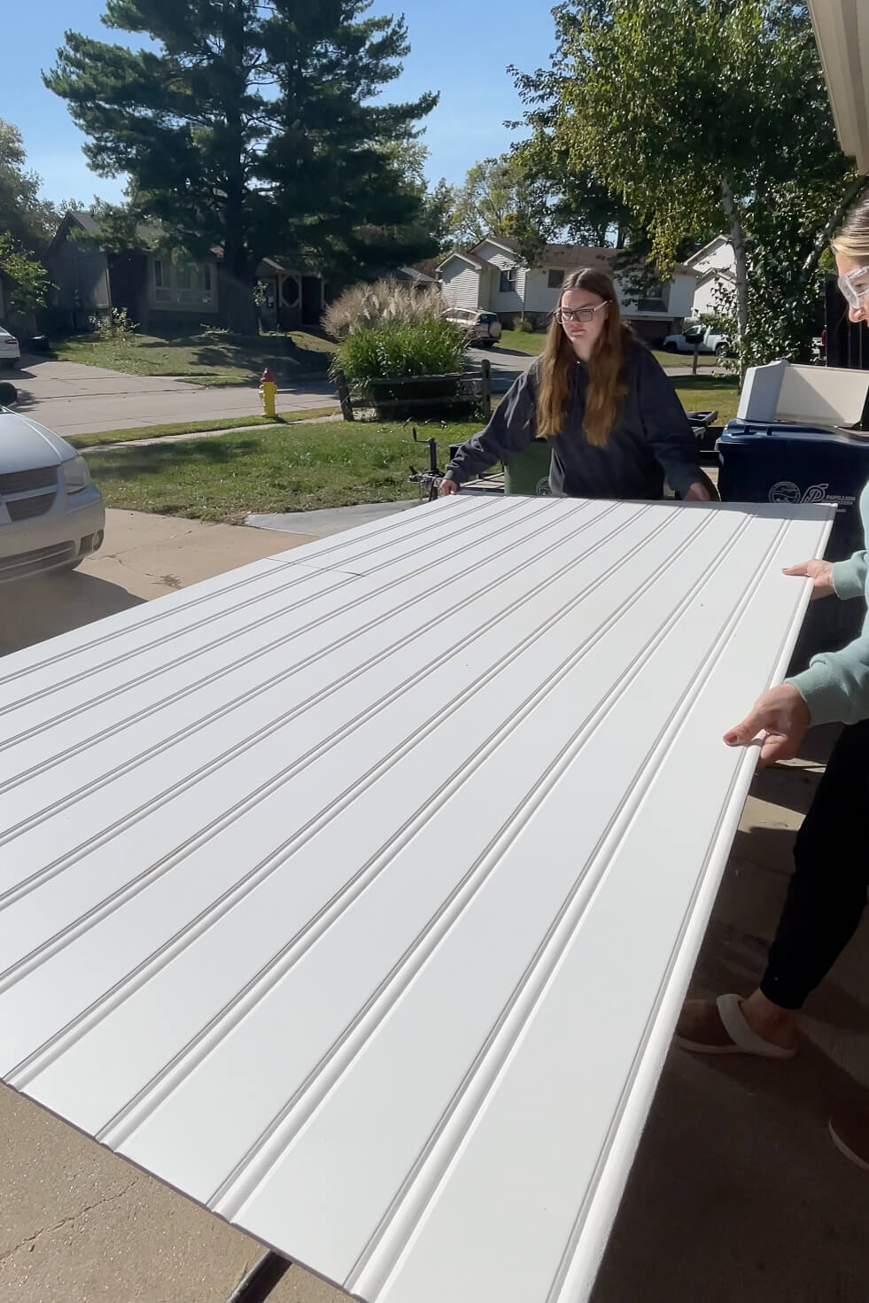 Using a table saw and the help of a friend to cut a beadboard panel down.